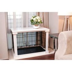 a dog crate with flowers in it sitting on the floor next to a white chair