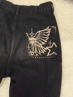 a pair of black jeans with white designs on them