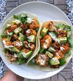 two tacos with chicken and avocado are on a plate