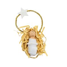 a wooden doll in a white dress with a star hanging from it's back