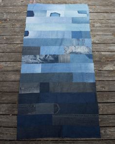 a blue patchwork rug is laying on a wooden floor and it looks like something out of space