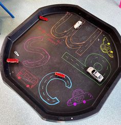 a chalk board with cars on it in the middle of a play area for children