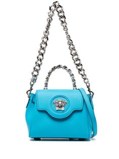 small La Medusa top-handle bag from Versace featuring ocean blue, calf leather, Medusa Head motif, logo stamp to the rear, single chain-link top handle, detachable chain-link shoulder strap, adjustable detachable shoulder strap, foldover top with magnetic fastening, main compartment, internal slip pocket and silver-tone hardware. Versace La Medusa Bag, Versace Bag, Prada Galleria, Designer Tote Bags, Medusa Head, Versace Bags, Vintage Purses, Bag Light, Online Shopping For Women