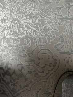 a gray and white wallpaper with an intricate design on it's sidewall