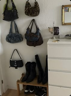 several purses and handbags are hanging on the wall next to a shoe rack