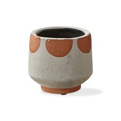 a pot with dots on it sitting on a white surface, ready to be used as a planter