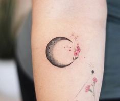 a woman's arm with a tattoo on it and a half moon in the middle