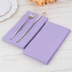 there is a fork and knife on the purple placemats next to each other