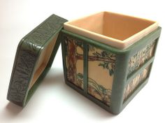 a green and white container with trees on it's sides is open to show the inside