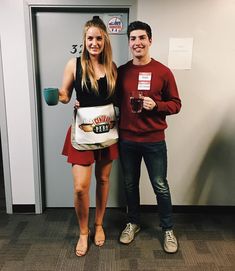 a man and woman standing next to each other in front of a door holding coffee mugs