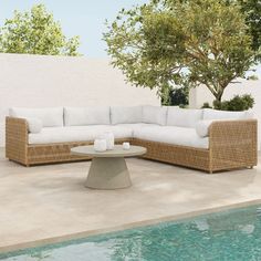 an outdoor sectional sofa next to a swimming pool