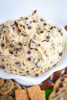 a white bowl filled with cookie dough and chocolate chip crackers on top of it