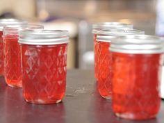 several jars filled with red liquid sitting on top of a table