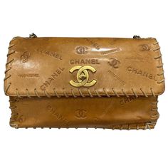 Borsa firmata Chanel, modello Maxi Jumbo, in edizione limitata, realizzata in vero cuoio con hardware dorati. Dotata di una patta con chisurua a girello logo CC, internamente rivestita in tela beige, abbastanza capiente. Munita di una tracolla intrecciata in pelle e catena per indossare la borsaa spalla. Completa internamente di tasca con chiusura a zip, la borsa è caratterizzata da rifiniture sul borso in cordino e di scritte e loghi impressi su tutta la superficie. Produzione anni 90′, si rese Chanel Camera Bag Brown, Chanel 2003 Bag, Chanel 1950, Chanel Crossbody Bag, Chanel Maxi, Vintage Designer Bags, Vintage Chanel Bag, Chanel Crossbody, Expensive Bag