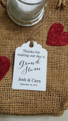 a jar with some red glitter hearts on it next to a tag that says thanks for making our day a grand jean