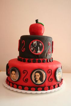 a three tiered cake decorated with pictures and an apple on the top, sitting on a table