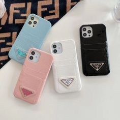 three iphone cases sitting next to each other on top of a white table with a blue and pink phone case