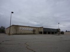 an empty parking lot in front of a building with a foodland sign on it