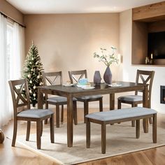 a dining room table and chairs in front of a fire place with a christmas tree