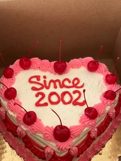 a heart shaped cake with the words since 200 written on it and cherries in the shape of a heart