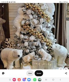 a white christmas tree decorated with gold and silver ornaments, polar bears and snowflakes