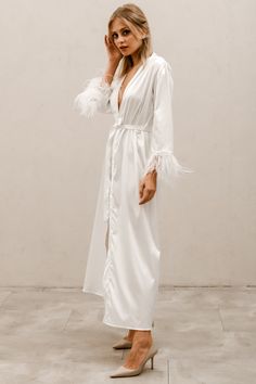 Our luxurious feather sleeved robe is the perfect accessory for getting ready on your big day. Made from a delicate blend of satin and silk, this robe is not only soft and comfortable to wear but also provides a touch of elegance to your pre-wedding preparations. Featuring faux ostrich feathers sewn onto the sleeves, this robe adds a regal touch to your bridal ensemble. With a flattering silhouette that drapes beautifully over the body, this robe is both stylish and practical. It is available in Robe With Feathers, Bridal Boxes, Bridal Robe, Standard Dress, Boise Idaho, Wedding Preparation, Vintage Glam, Bridal Robes, Ostrich Feathers