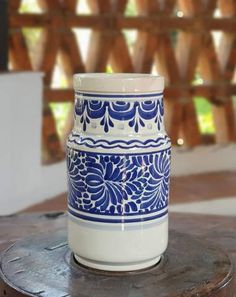 a blue and white vase sitting on top of a wooden table