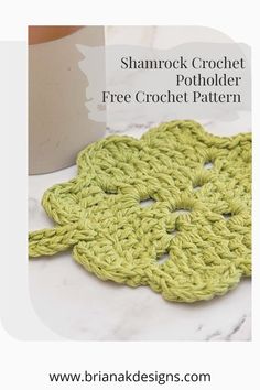 a crocheted potholder is sitting on a table next to a coffee cup