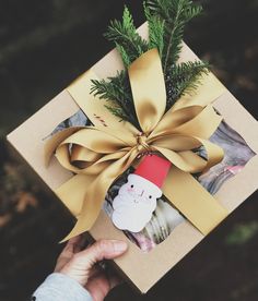 a person holding a present wrapped in brown paper