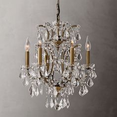 a chandelier hanging from the ceiling with crystal drops on it and two candles