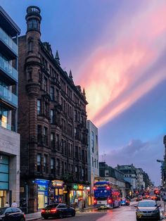 a city street filled with lots of traffic under a cloudy sky at sunset or dawn