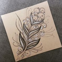 a piece of paper with a drawing of a peacock feather on it's side