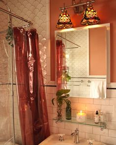 a bathroom with a sink, mirror and shower curtain