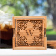 a wooden block with the letter w on it sitting next to a jar of liquid