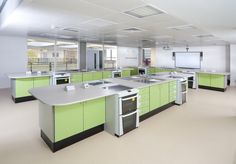 an empty kitchen with green cabinets and white counter tops is seen in this image from the front view