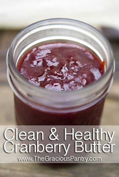 a jar filled with cranberry butter sitting on top of a wooden table