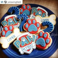 decorated dog paw cookies on a blue plate