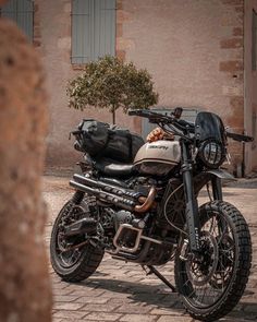 a motorcycle parked on the side of a brick road