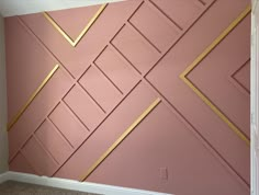 a pink wall with gold lines painted on it