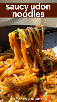 a spoon full of noodles with sauce and vegetables in it, on top of a skillet