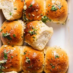 several rolls with cheese and herbs in a white dish