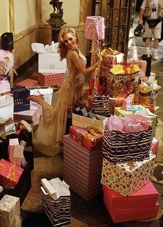 a woman standing next to lots of presents