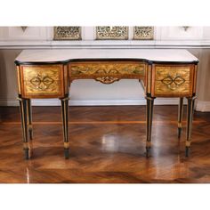 an antique desk with marble top and brass accents