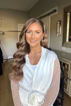 a woman standing in front of a mirror wearing a white dress with polka dots on it