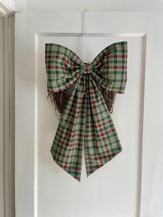 a green and red bow hanging on the side of a door