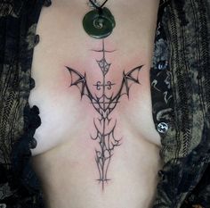 a woman with a tattoo on her chest has a green tag attached to the cross