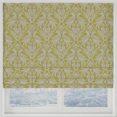 a window with a green and white patterned roman blind