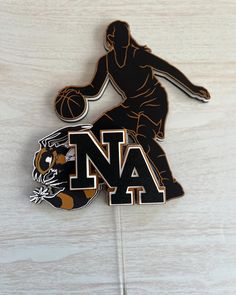 a pin with the letter na on it and a basketball player holding a ball