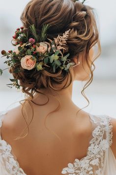 a woman with flowers in her hair wearing a wedding dress and holding a flower crown