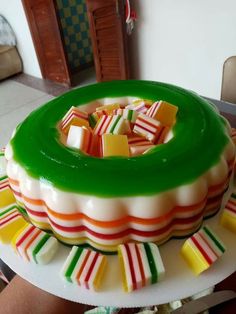 a green and white cake sitting on top of a table next to a pile of candy